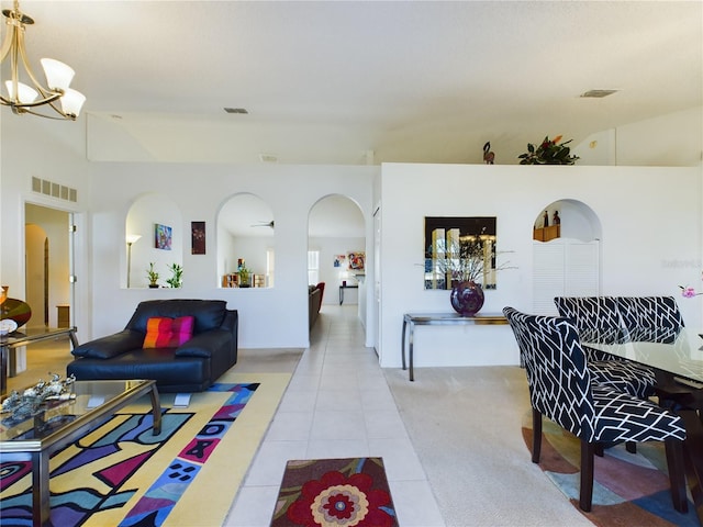 living area featuring an inviting chandelier, visible vents, light tile patterned floors, and arched walkways