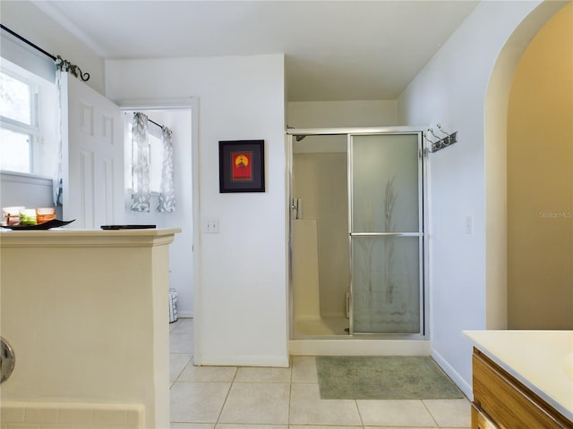 bathroom with baseboards, a stall shower, vanity, and tile patterned floors