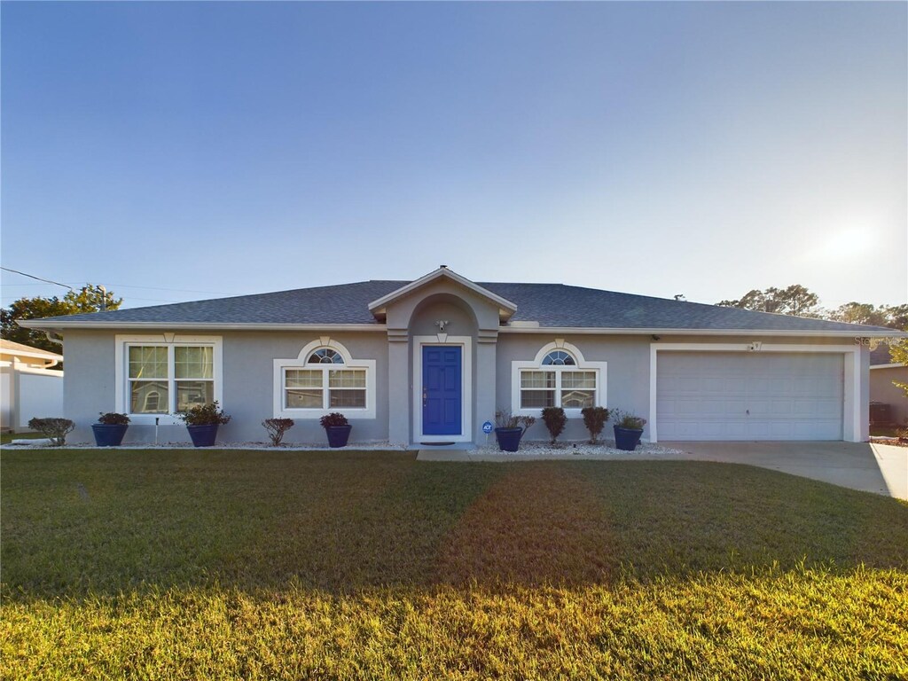 9 Kaiser Pl, Palm Coast, FL 32164 - single story home with stucco siding, concrete driveway, a front yard, and a garage