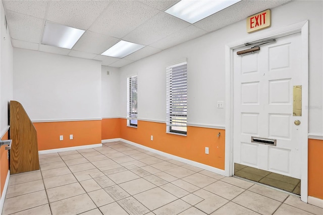 spare room with a drop ceiling and light tile patterned floors