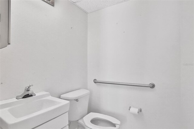 bathroom with a textured ceiling, toilet, and sink