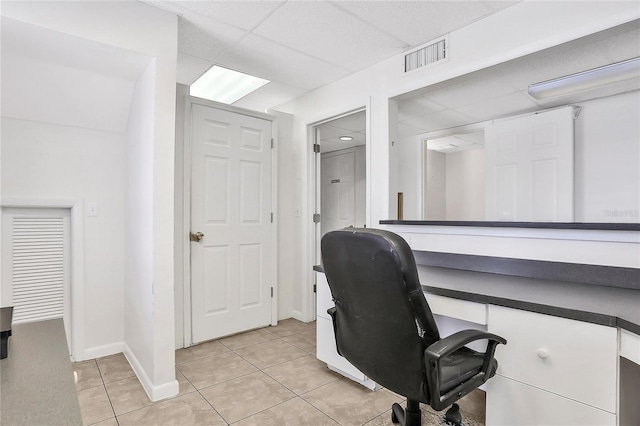 tiled office space with a paneled ceiling