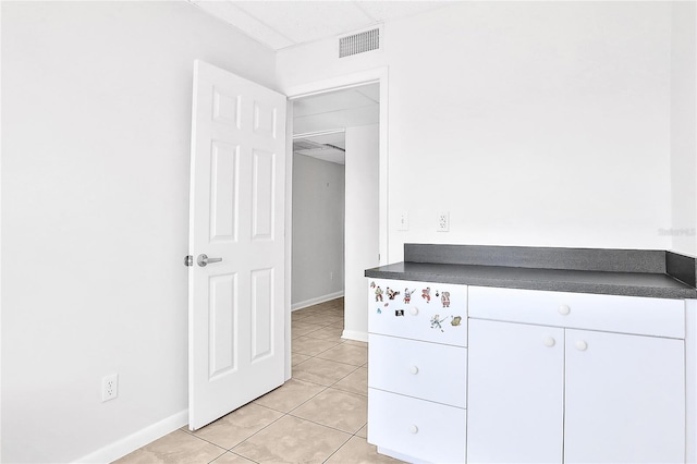 kitchen featuring light tile patterned floors and white cabinetry