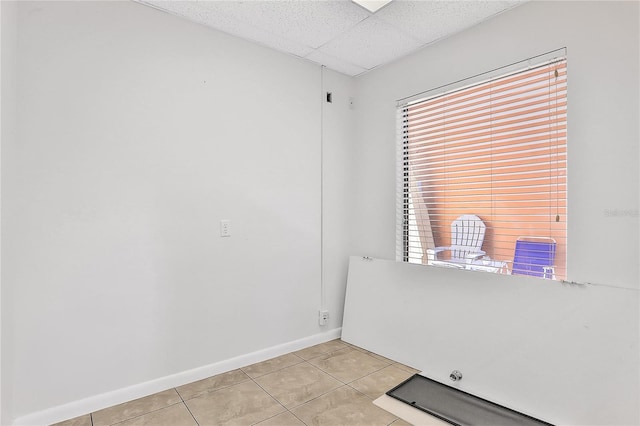 interior space with light tile patterned floors, a paneled ceiling, and plenty of natural light