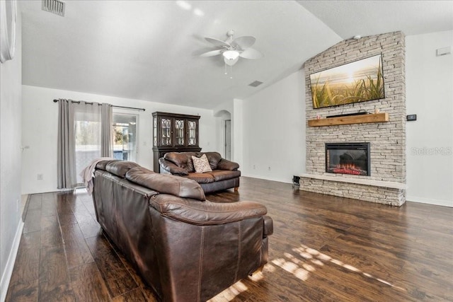 living room with dark hardwood / wood-style flooring, a stone fireplace, ceiling fan, and lofted ceiling