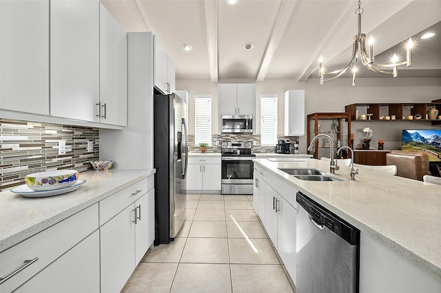 kitchen with pendant lighting, white cabinetry, sink, and stainless steel appliances