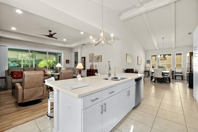 kitchen with sink, hanging light fixtures, stainless steel dishwasher, white cabinets, and ceiling fan with notable chandelier