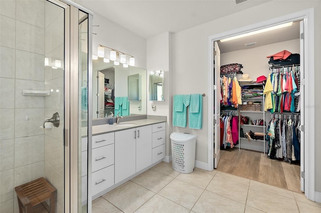 bathroom with tile patterned floors, vanity, and a shower with door