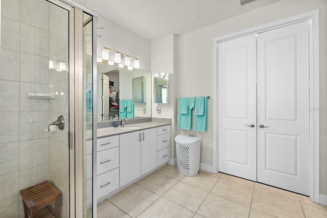 bathroom with tile patterned floors, vanity, and walk in shower