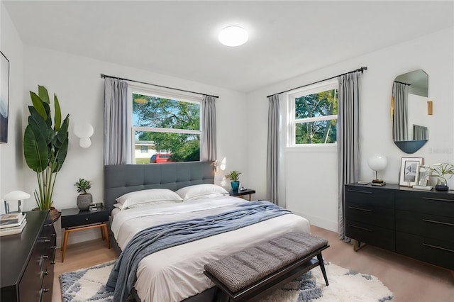 bedroom featuring multiple windows and light hardwood / wood-style flooring