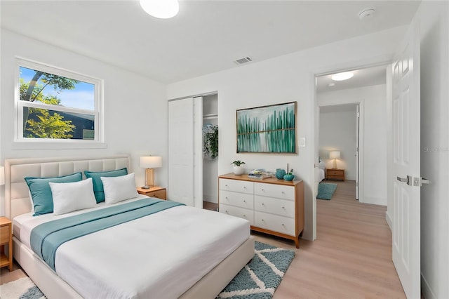 bedroom with light wood-type flooring and a closet