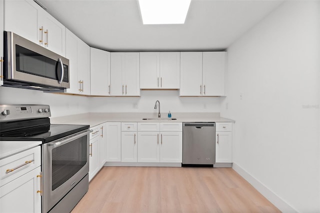 kitchen featuring light wood-type flooring, white cabinetry, sink, and appliances with stainless steel finishes