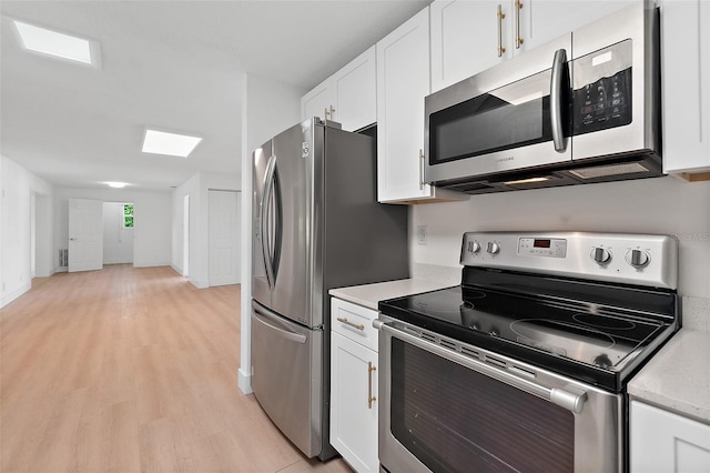 kitchen with light wood-type flooring, white cabinetry, and stainless steel appliances