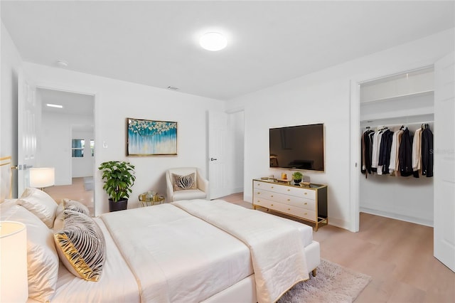 bedroom with light hardwood / wood-style floors and a closet