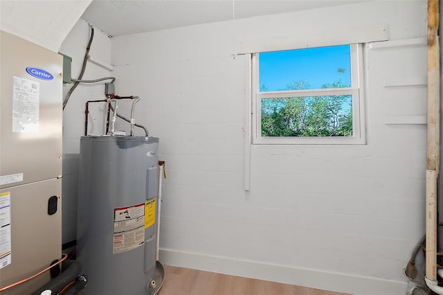 utility room featuring electric water heater and heating unit