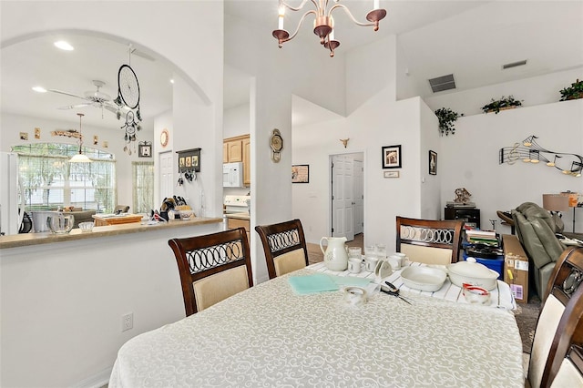 dining area with ceiling fan with notable chandelier