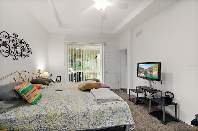 bedroom with ceiling fan, a raised ceiling, carpet floors, and access to outside