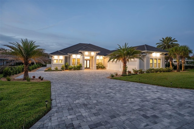 mediterranean / spanish-style house featuring a yard and a garage