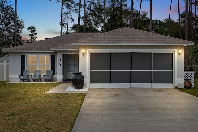 ranch-style home featuring a yard and a garage