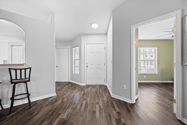 foyer featuring a textured ceiling, ceiling fan, and dark hardwood / wood-style floors