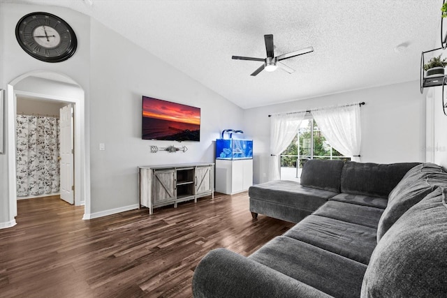 living room featuring dark hardwood / wood-style floors, ceiling fan, a textured ceiling, and vaulted ceiling