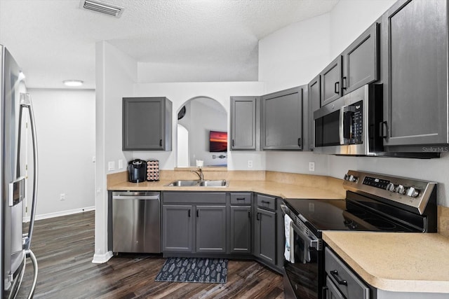 kitchen with gray cabinetry, sink, and stainless steel appliances