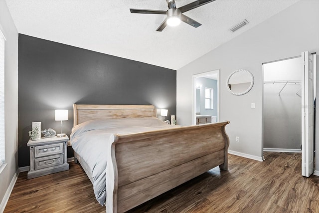 bedroom featuring ceiling fan, dark hardwood / wood-style floors, a walk in closet, and a closet