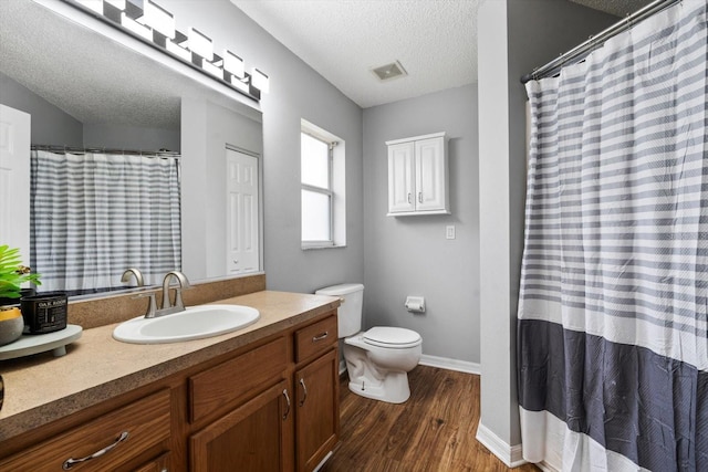 bathroom featuring toilet, vanity, a textured ceiling, and hardwood / wood-style flooring