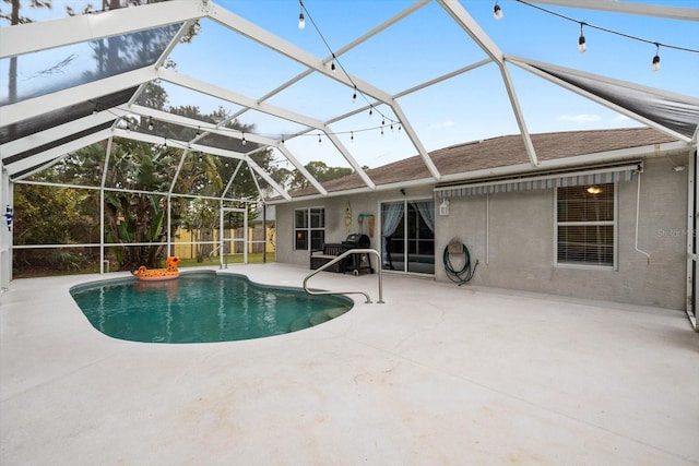 view of pool featuring glass enclosure and a patio