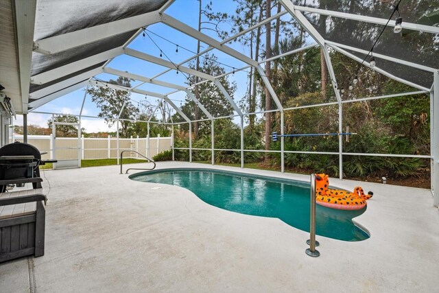 view of pool with glass enclosure and a patio area