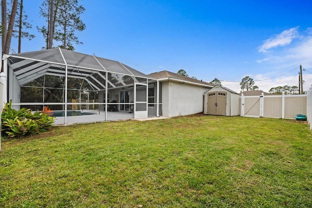 rear view of house featuring glass enclosure, a storage unit, and a lawn