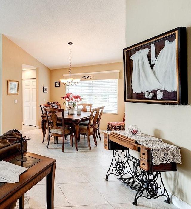 tiled dining space with lofted ceiling and a chandelier