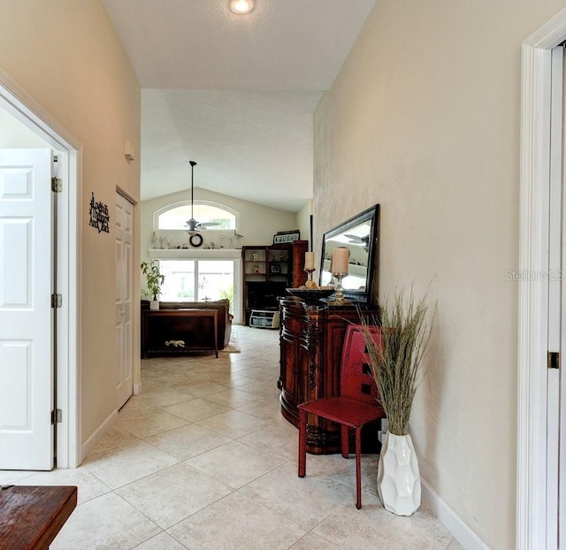 hallway featuring vaulted ceiling and light tile patterned floors