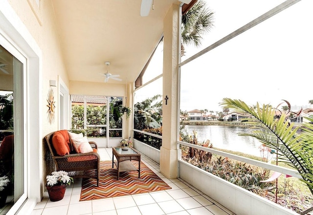 sunroom featuring a water view and ceiling fan