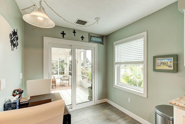 entryway featuring plenty of natural light, light hardwood / wood-style floors, and a textured ceiling