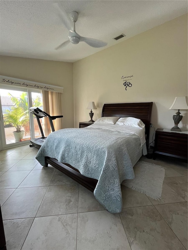 bedroom featuring access to outside, a textured ceiling, and ceiling fan