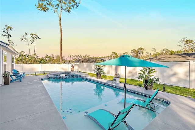 pool at dusk featuring an in ground hot tub, a water view, and a patio area