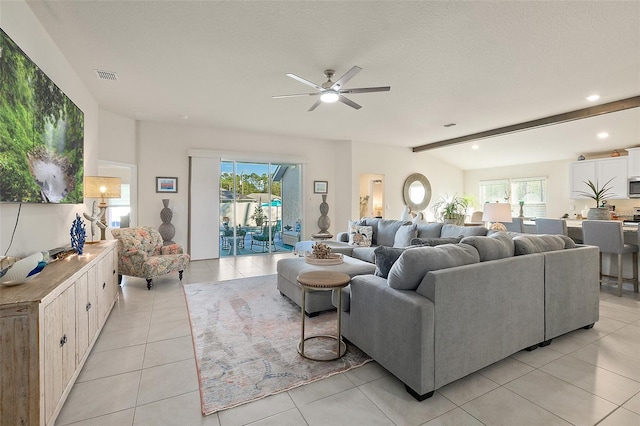 living room with a wealth of natural light, a textured ceiling, light tile patterned floors, and ceiling fan