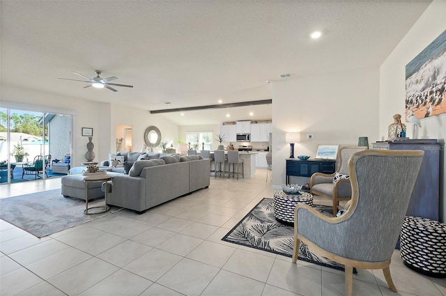 living room with light tile patterned floors, a textured ceiling, a wealth of natural light, and ceiling fan