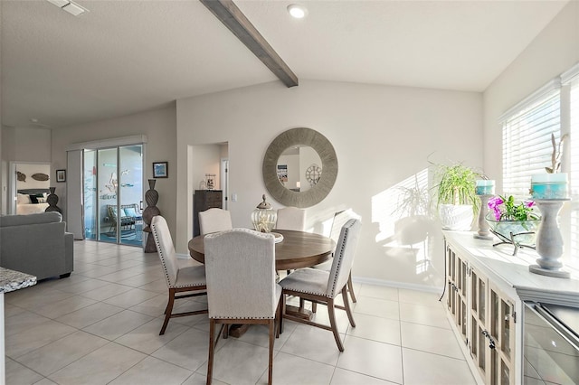 tiled dining space featuring vaulted ceiling with beams