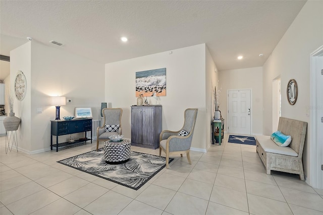 living area featuring light tile patterned flooring and a textured ceiling