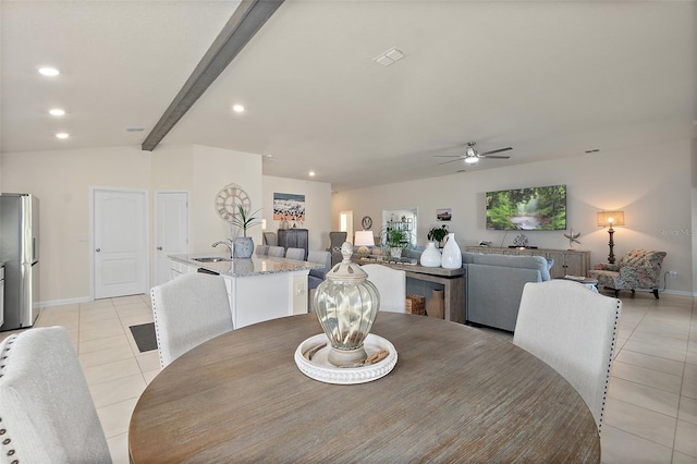 tiled dining room with beam ceiling, ceiling fan, and sink