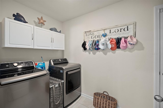 washroom featuring cabinets, light tile patterned floors, and washer and dryer