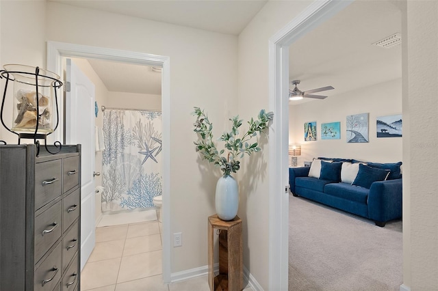 interior space with walk in shower, ceiling fan, tile patterned flooring, and toilet