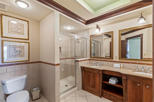 bathroom with vanity, toilet, ornamental molding, tile walls, and an enclosed shower