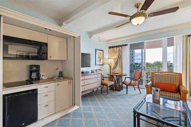 interior space featuring sink, ceiling fan, a textured ceiling, beam ceiling, and light colored carpet
