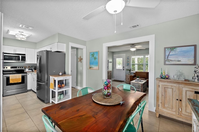 tiled dining area with a textured ceiling