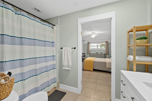 bathroom with vanity, tile patterned flooring, ceiling fan, toilet, and a textured ceiling