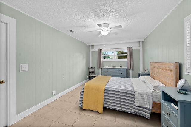 tiled bedroom featuring ceiling fan and wood walls