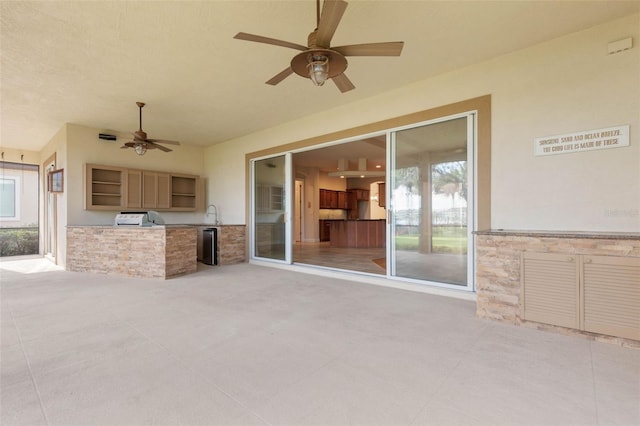 view of patio with area for grilling, ceiling fan, and sink